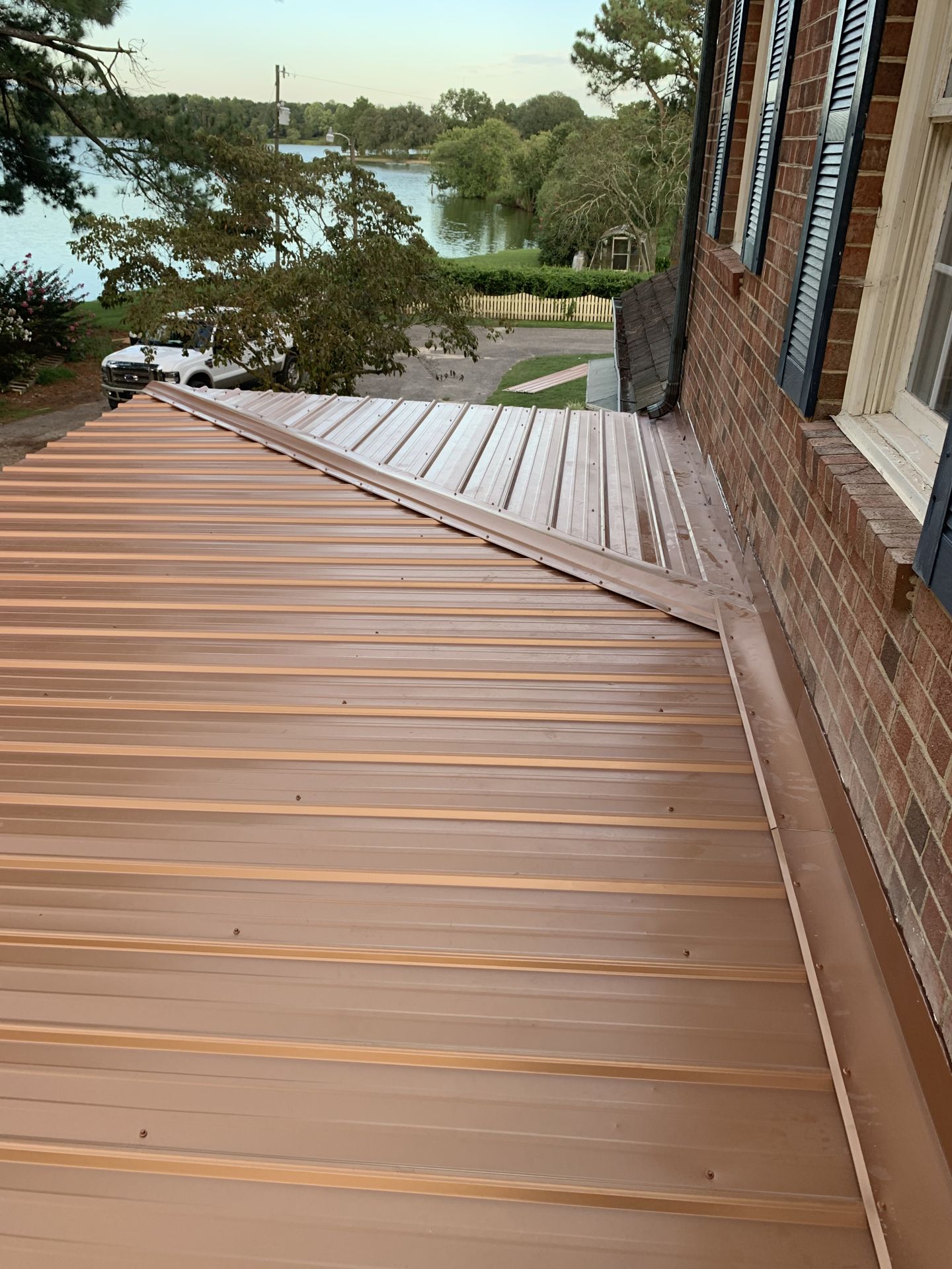 Copper-tone metal roofing detail on brick home