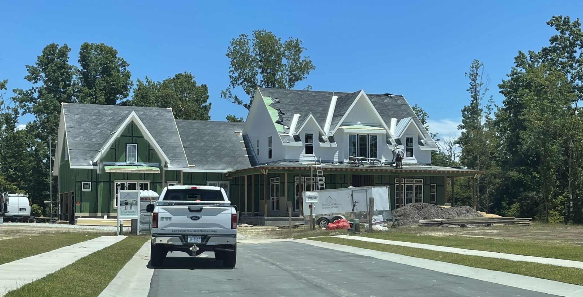 Street view of completed homes with new metal roofing