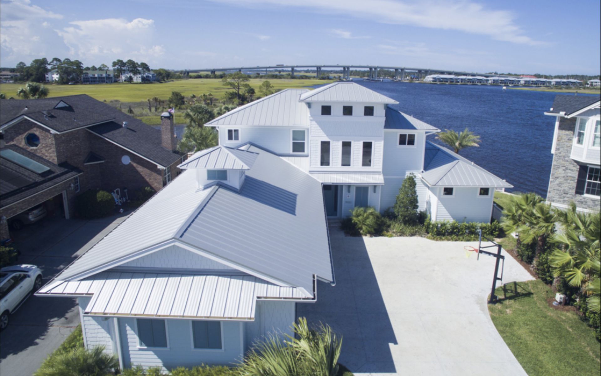 Aerial view of waterfront home with metal roof