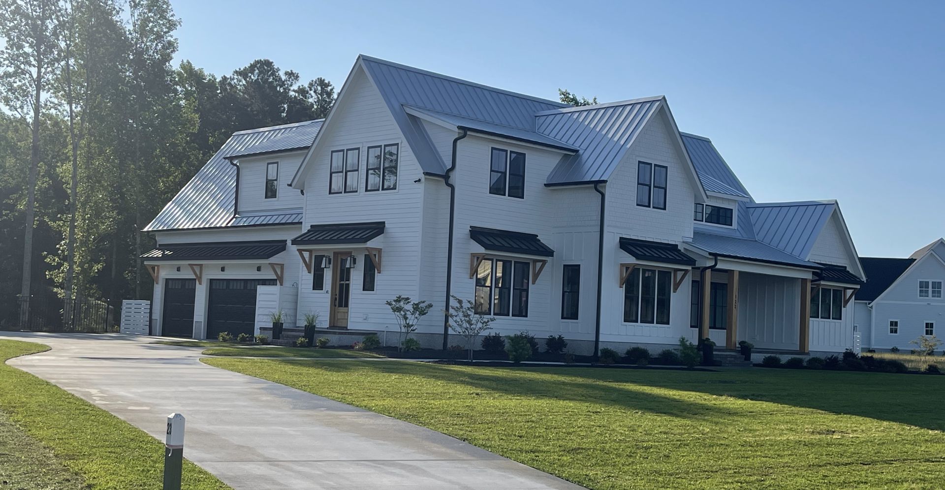 White farmhouse with gray metal roofing
