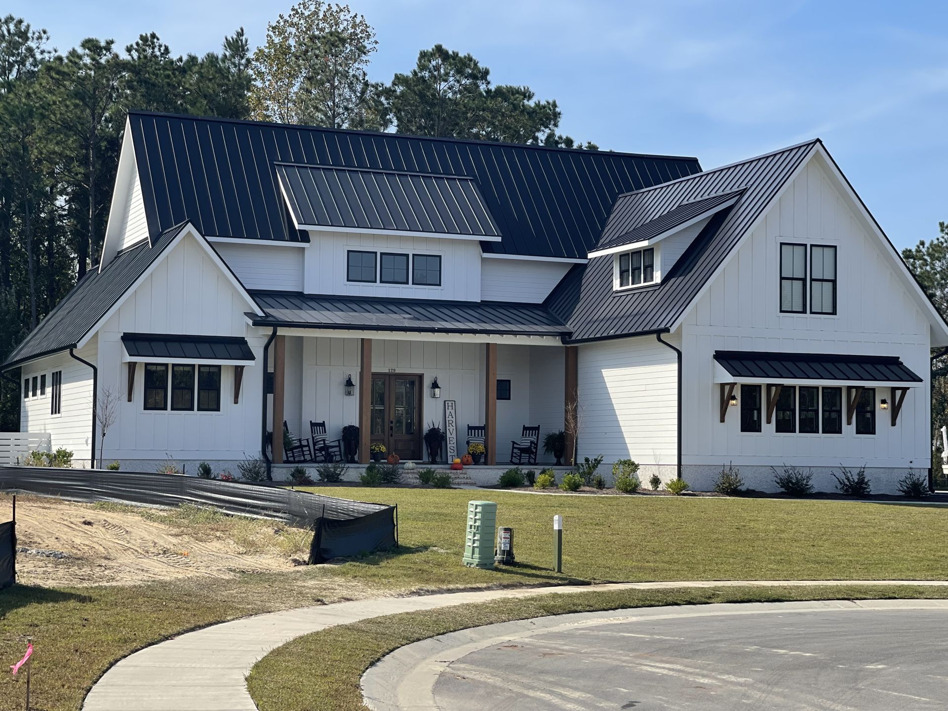 Completed modern farmhouse with black standing seam metal roof